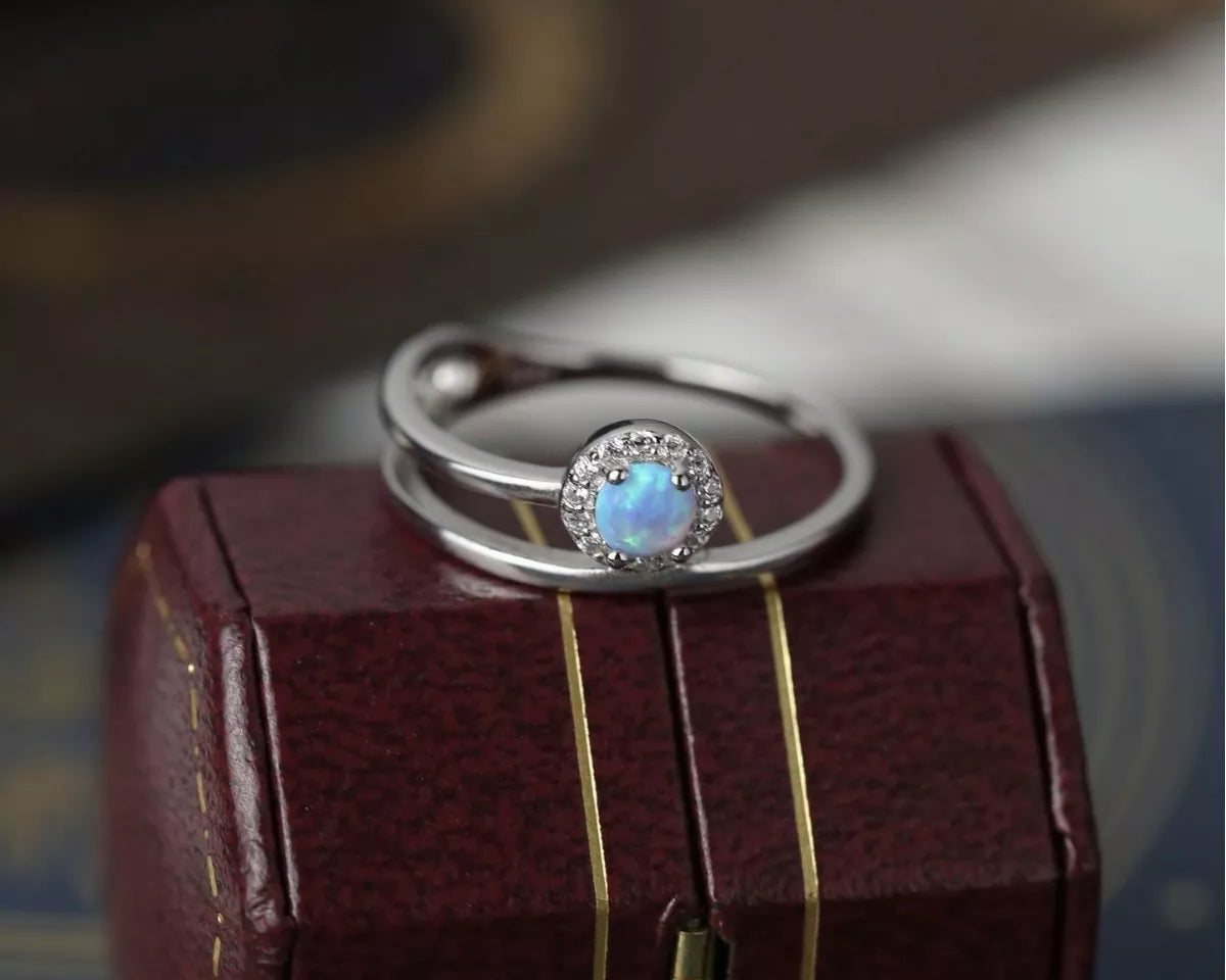 NYLD Glamour Collection by NEWYORKLISTED: Silver ring with a blue gemstone on a wooden box