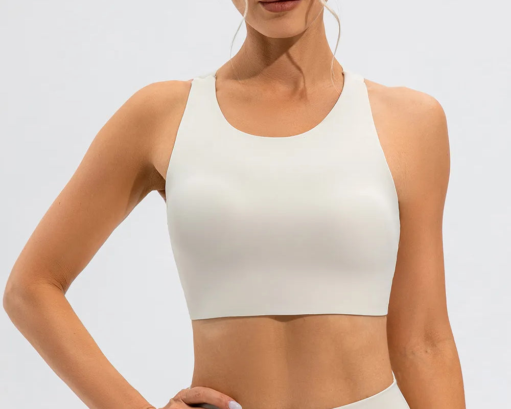 NEWYORKLISTED ACTIVEWEAR COLLECTION: Woman wearing a white sports bra and leggings on a light gray background
