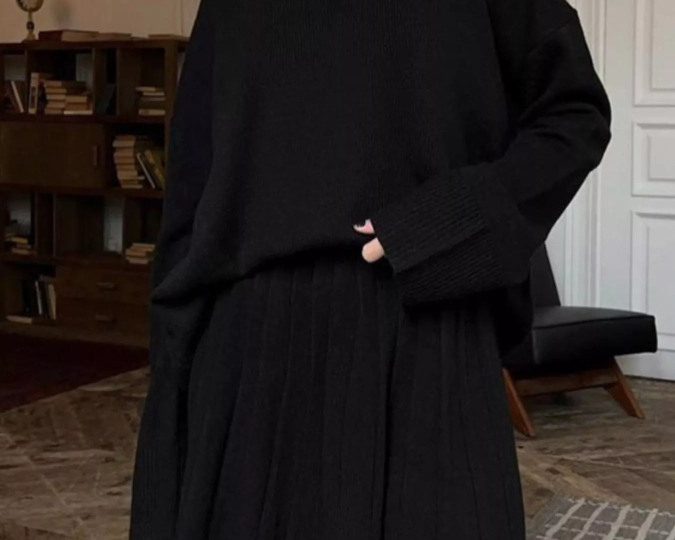 NEWYORKLISTED STYLE COLLECTION: Woman wearing a black outfit in an indoor setting