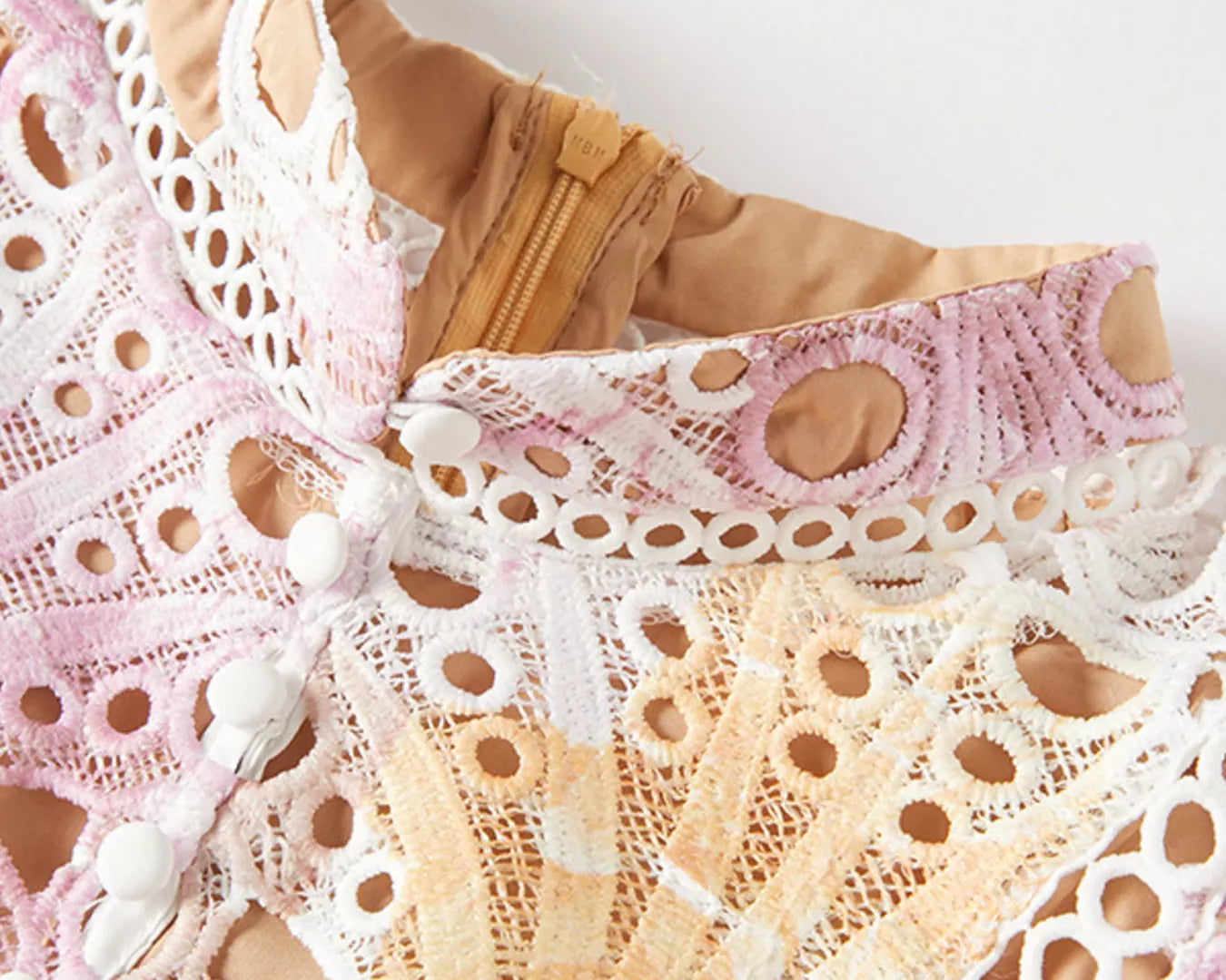 NEWYORKLISTED STYLE COLLECTION: Close-up of lace lingerie with pink and beige tones on a white background