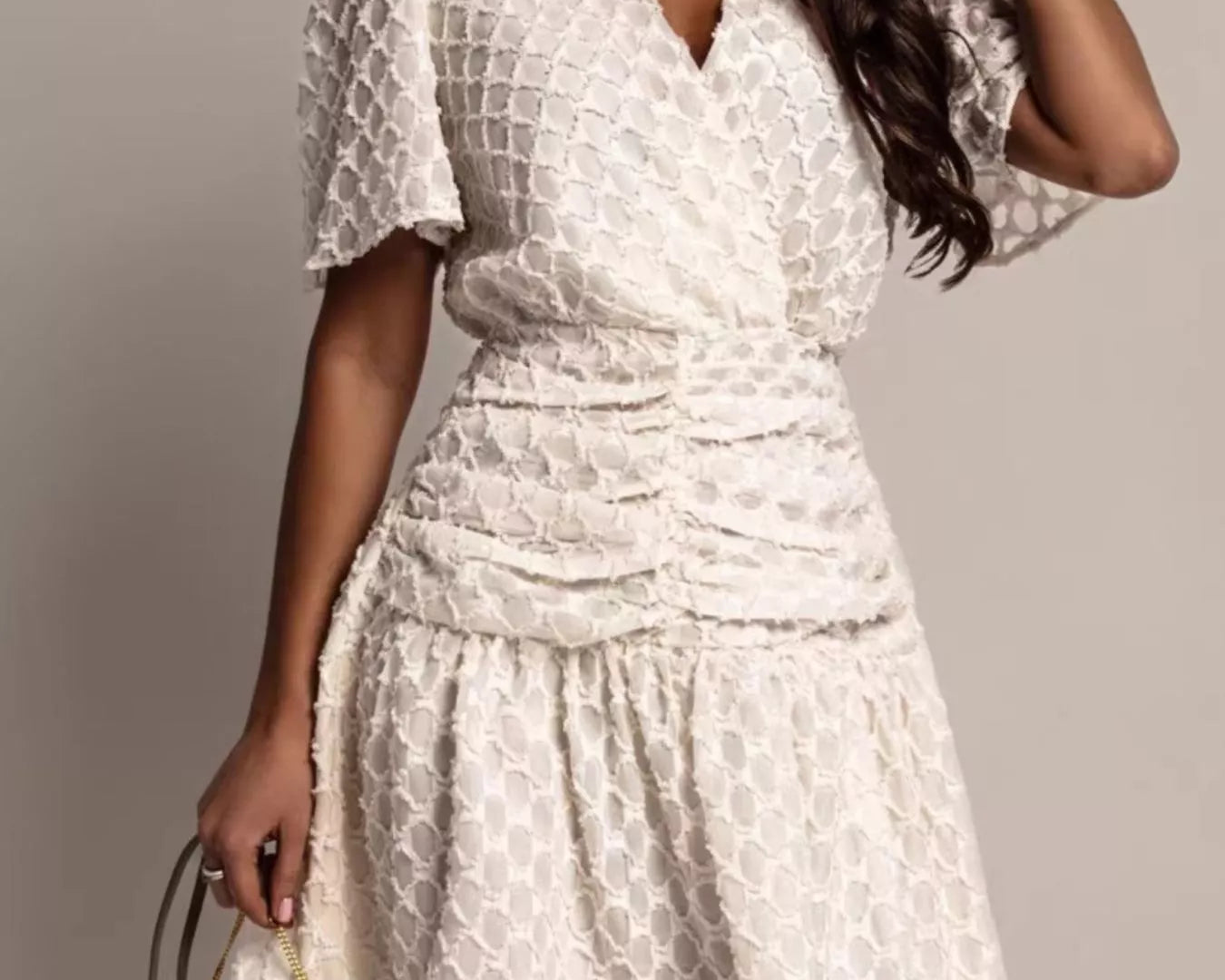 NEWYORKLISTED STYLE COLLECTION: Woman wearing a white lace dress against a neutral background