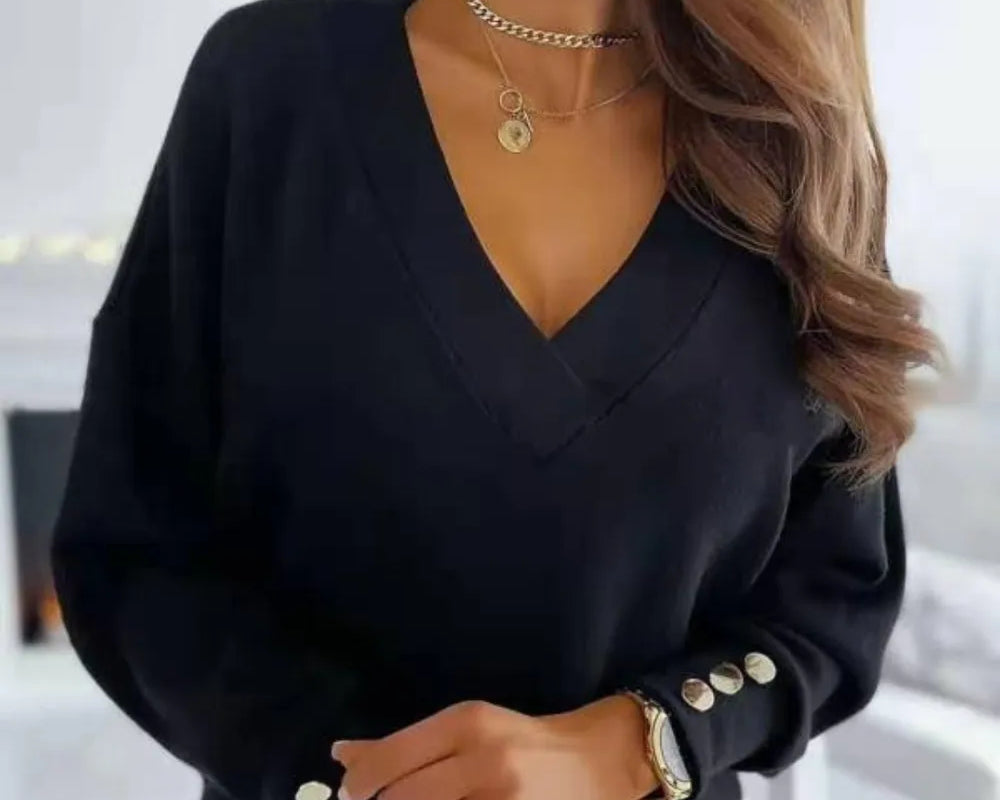 NEWYORKLISTED STYLE COLLECTION: Black sweater with button details worn by a person, on a blurred indoor background