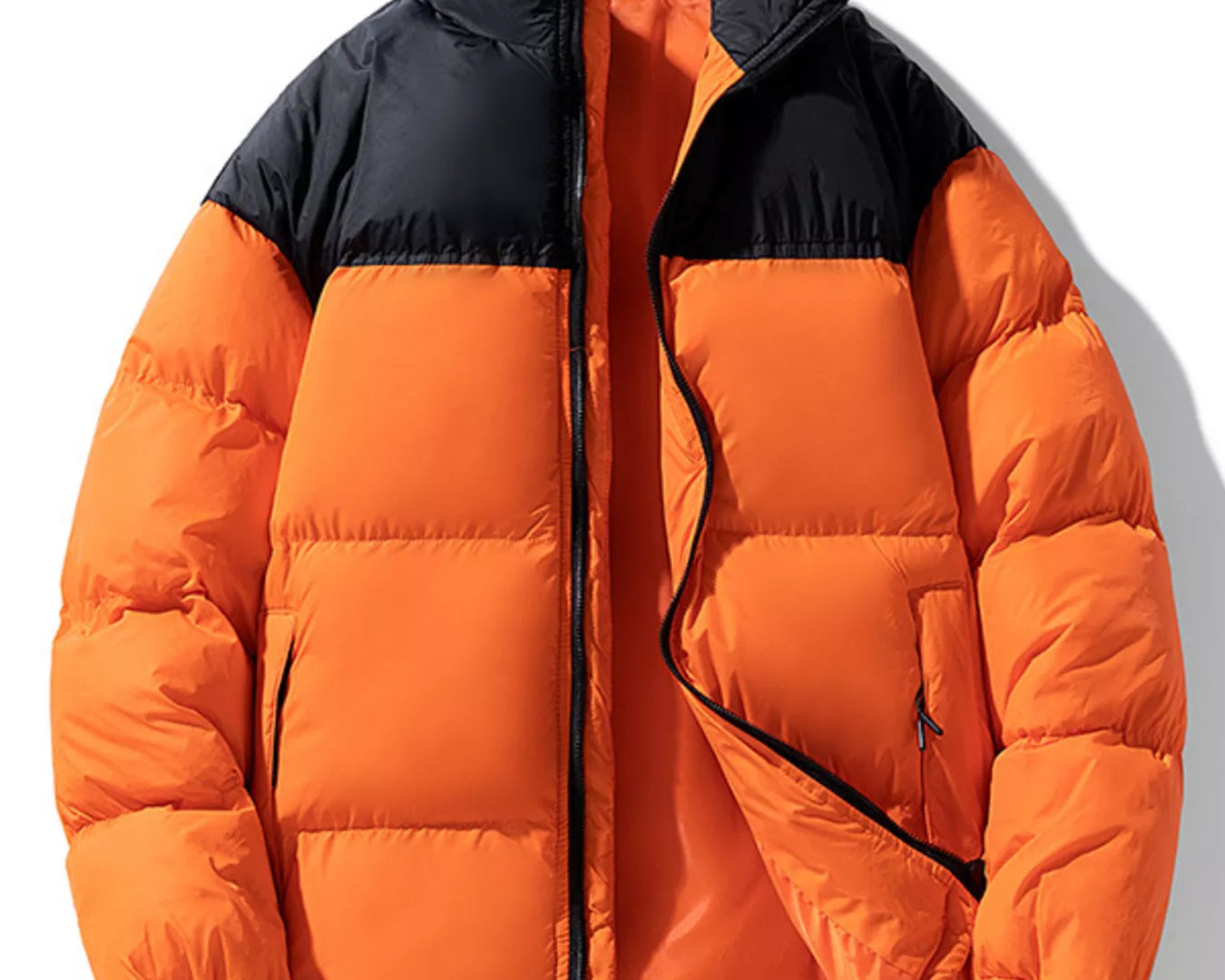 NEWYORKLISTED ATLAS MEN’S COLLECTION: Orange puffer jacket with black accents on a white background