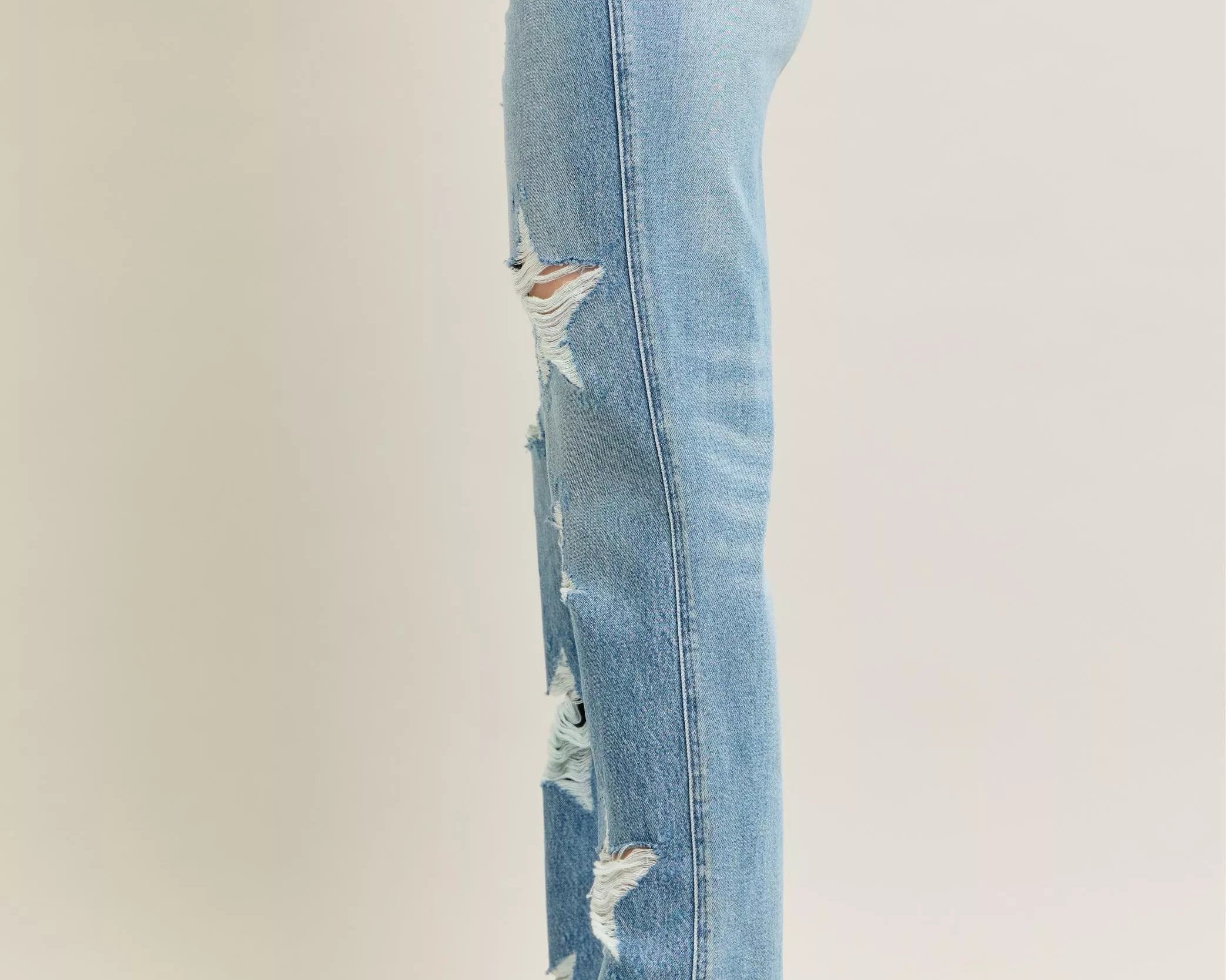 NEWYORKLISTED STYLE COLLECTION: Light blue distressed jeans worn by a person on a plain background