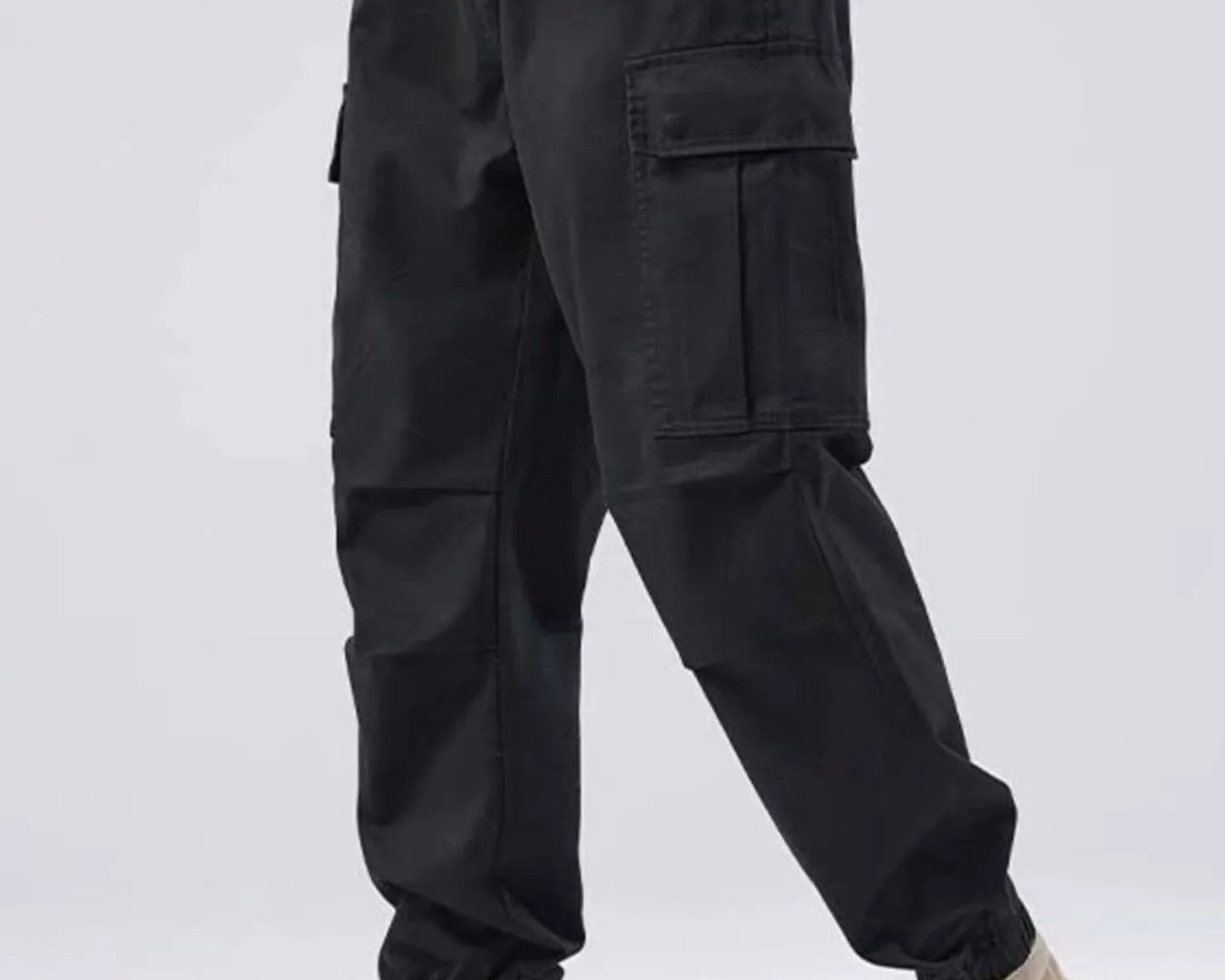 NEWYORKLISTED ATLAS MEN'S COLLECTION: Person wearing black cargo pants and beige boots on a white background