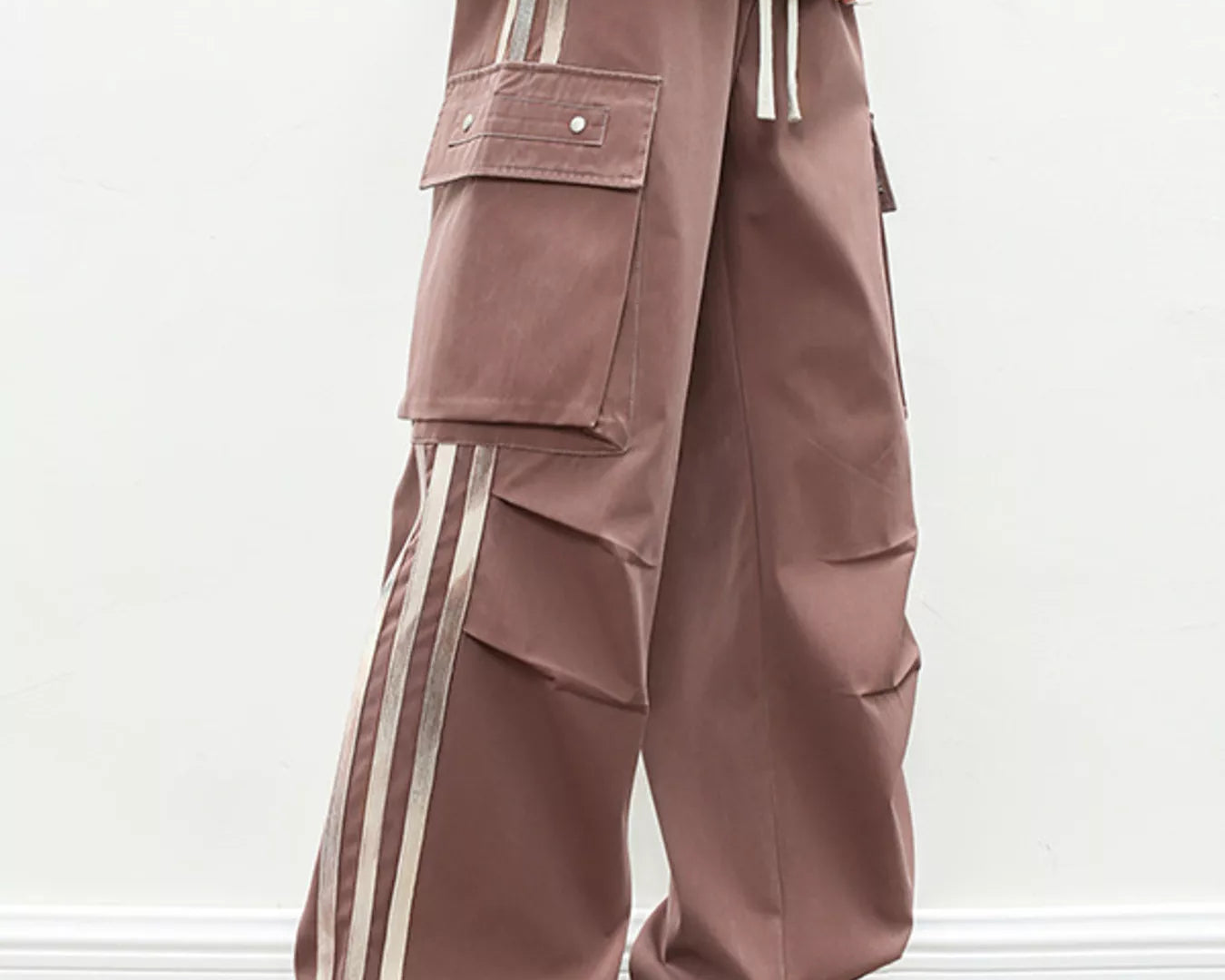 NEWYORKLISTED ATLAS MEN's COLLECTION: Brown cargo pants with white stripes worn by a person on a plain background