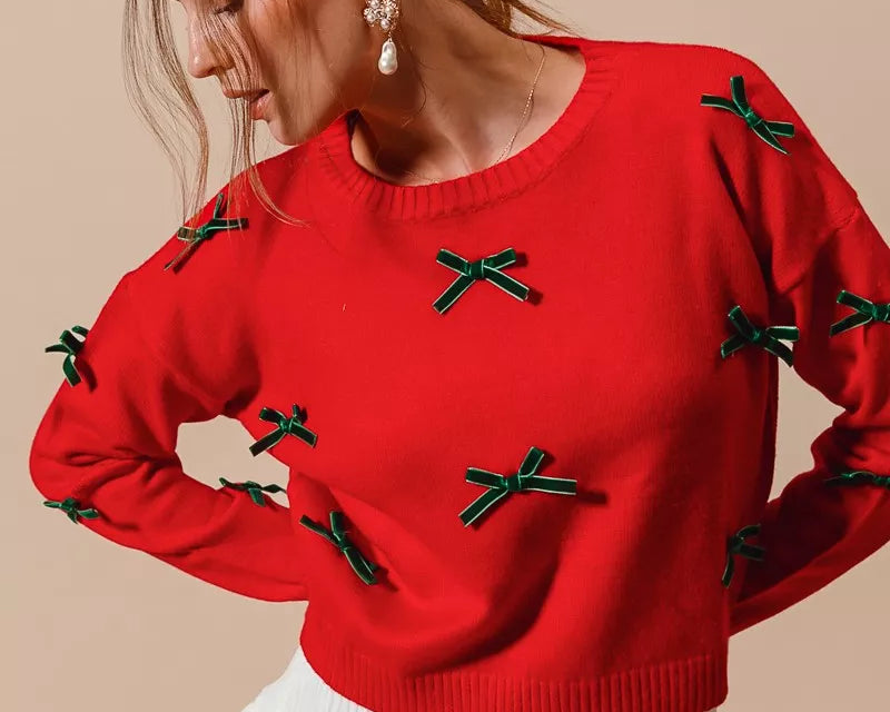 NEWYORKLISTED STYLE COLLECION: Woman wearing a red sweater with green accents on a beige background