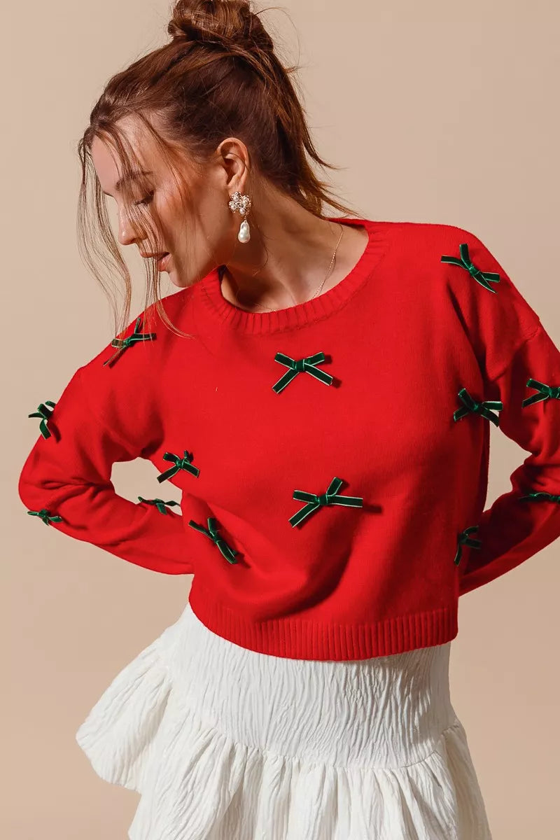 NEWYORKLISTED STYLE COLLECION: Woman wearing a red sweater with green accents on a beige background