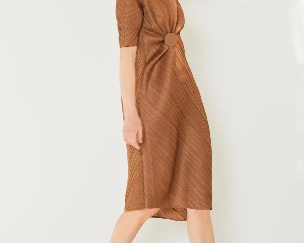 Woman wearing a brown dress against a white background: NEWYORKLISTED STYLE COLLECTION