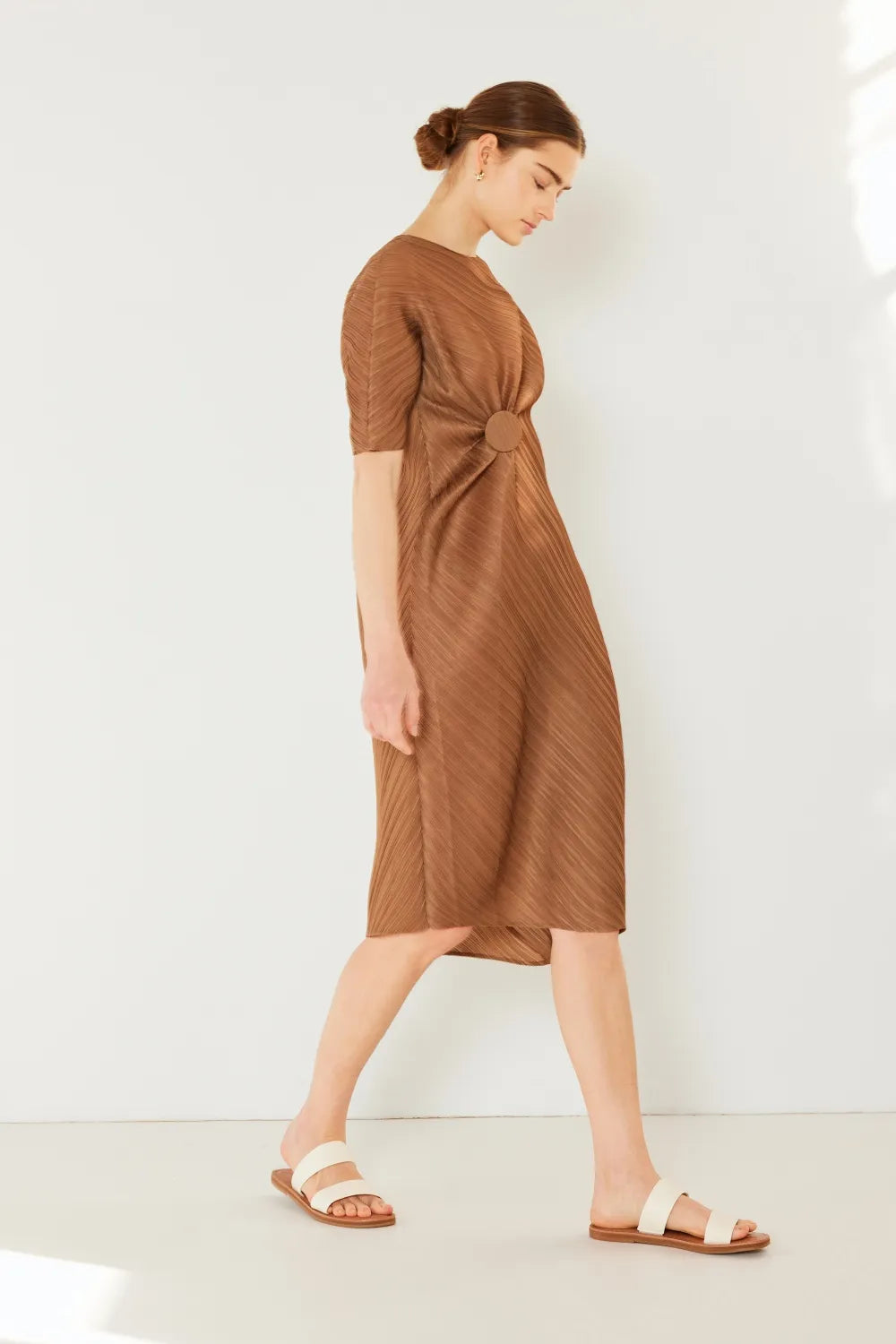 Woman wearing a brown dress against a white background: NEWYORKLISTED STYLE COLLECTION