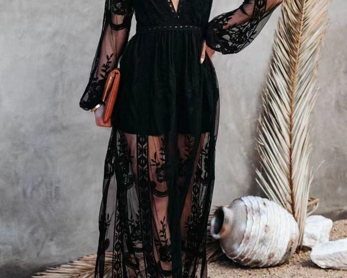 NEWYORKLISTED STYLE COLLECTION: Woman wearing a black lace dress with sheer panels against a neutral background