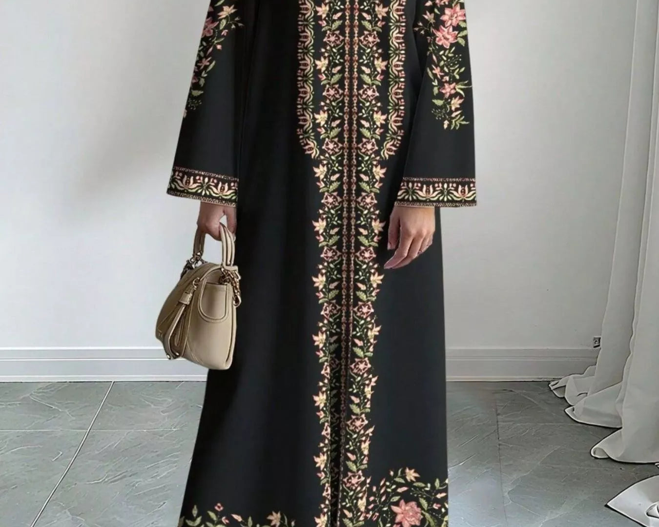 NEWYORKLISTED STYLE COLLECTION: Woman wearing a black dress with floral embroidery in a minimal indoor setting