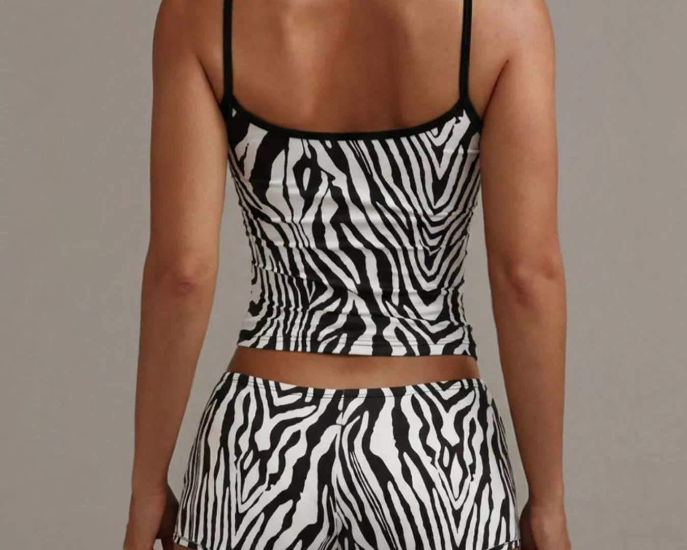 NEWYORKLISTED INTIMATE APPAREL COLLECTION: Person wearing a zebra print two-piece set against a neutral background