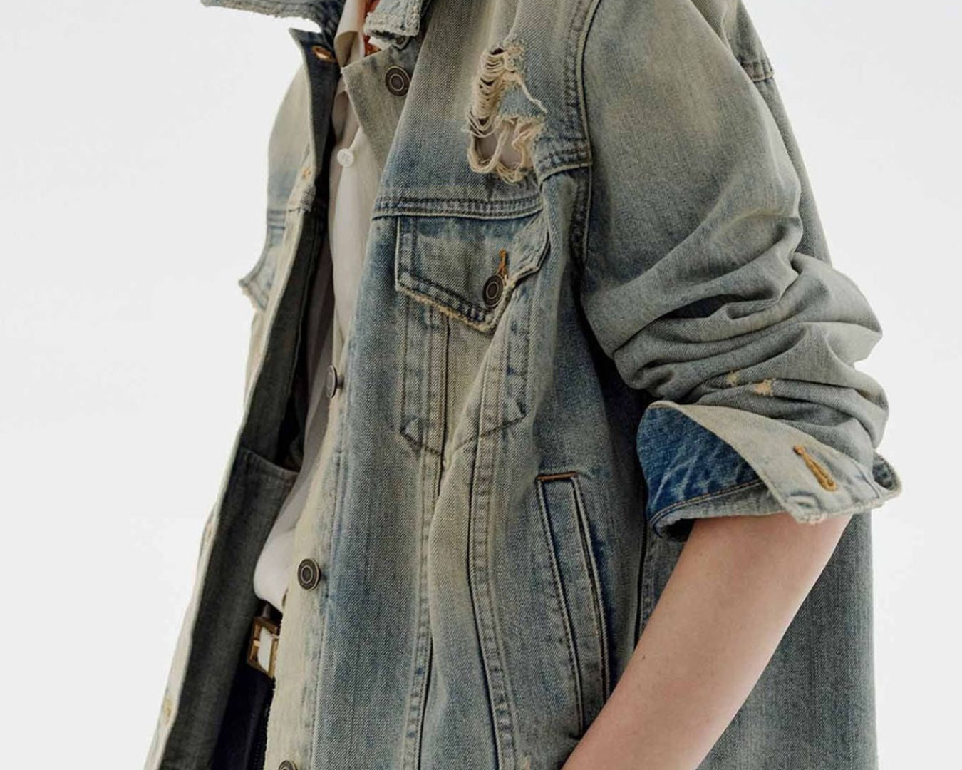 NEWYORKLISTED STYLE COLLECTION: Person wearing a denim jacket with embroidered designs on a white background