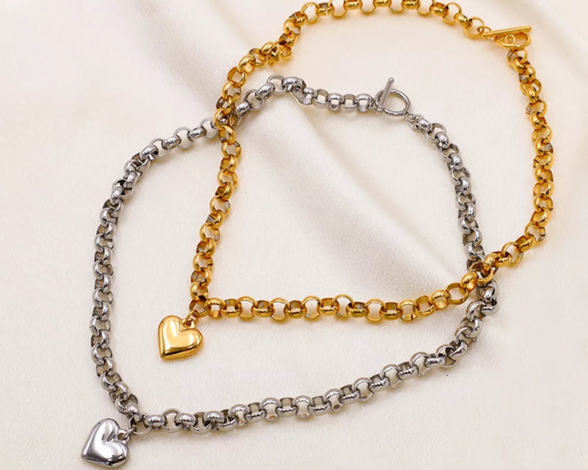 NYLD Glamour Collection by NEWYORKLISTED: Two chain bracelets, one gold and one silver, on a light fabric background.