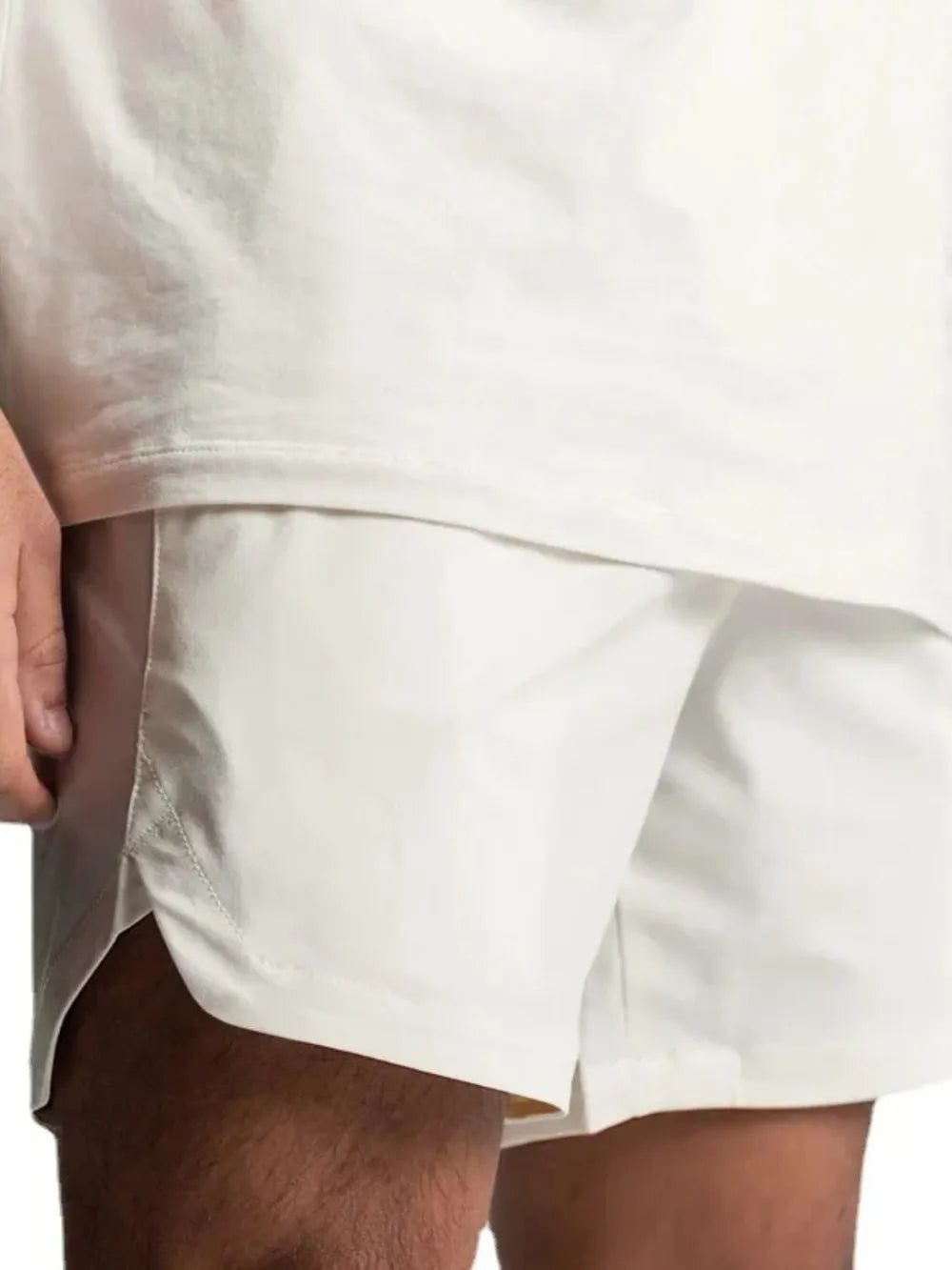 NEWYORKLISTED ATLAS MEN'S COLLECTION: Close-up of a person wearing a white t-shirt and beige shorts on a white background