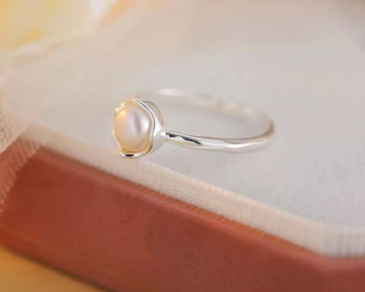 Silver ring with a pearl on a soft fabric background