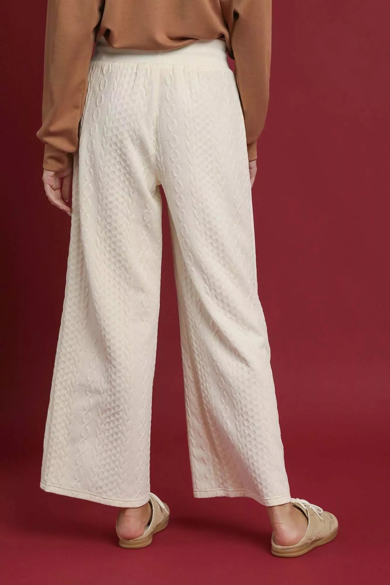 NEWYORKLISTED STYLE COLLECTION: Person wearing beige textured pants on a red background