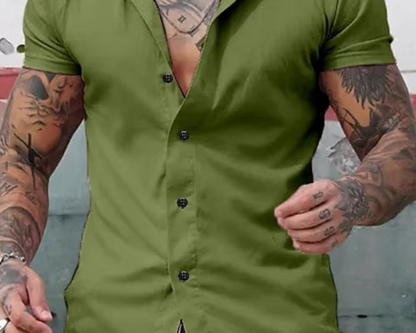 NEWYORKLISTED ATLAS MEN's COLLECTION: Man wearing a green button-up shirt with tattoos on arms and neck.