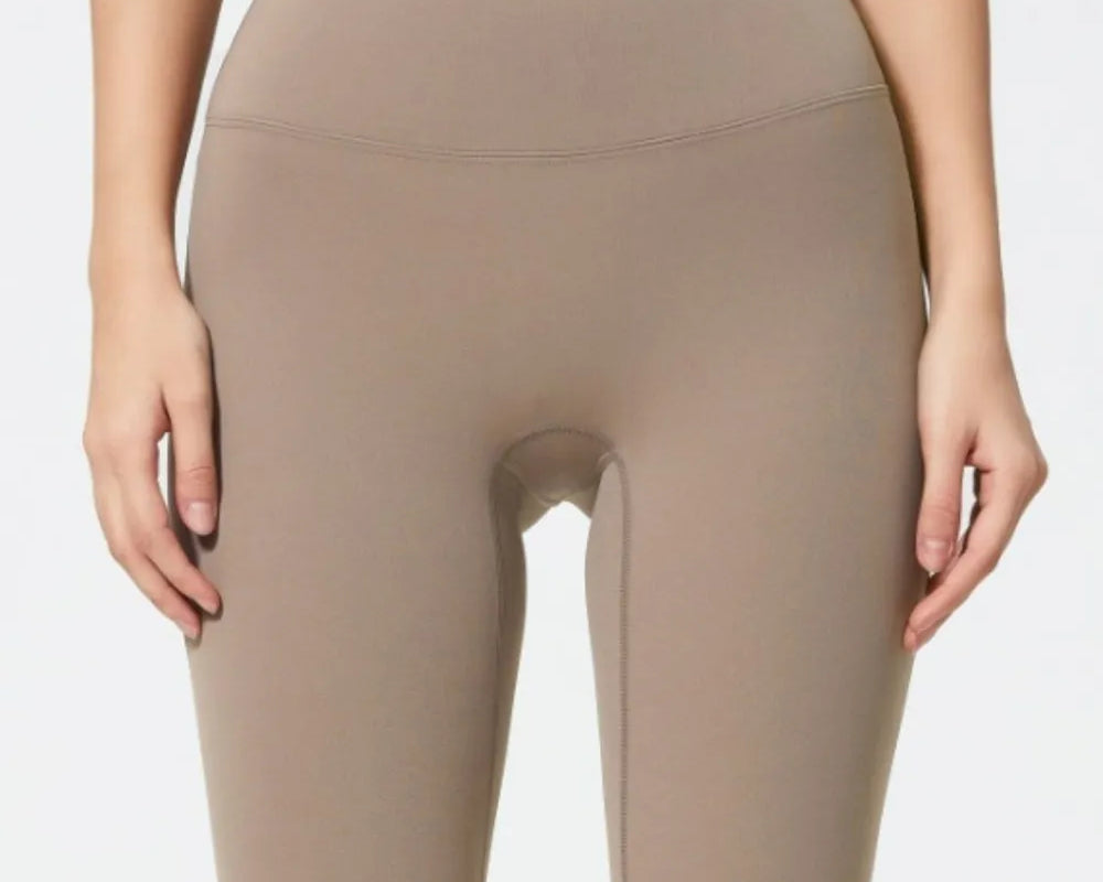 Beige high-waisted leggings worn by a person on a white background