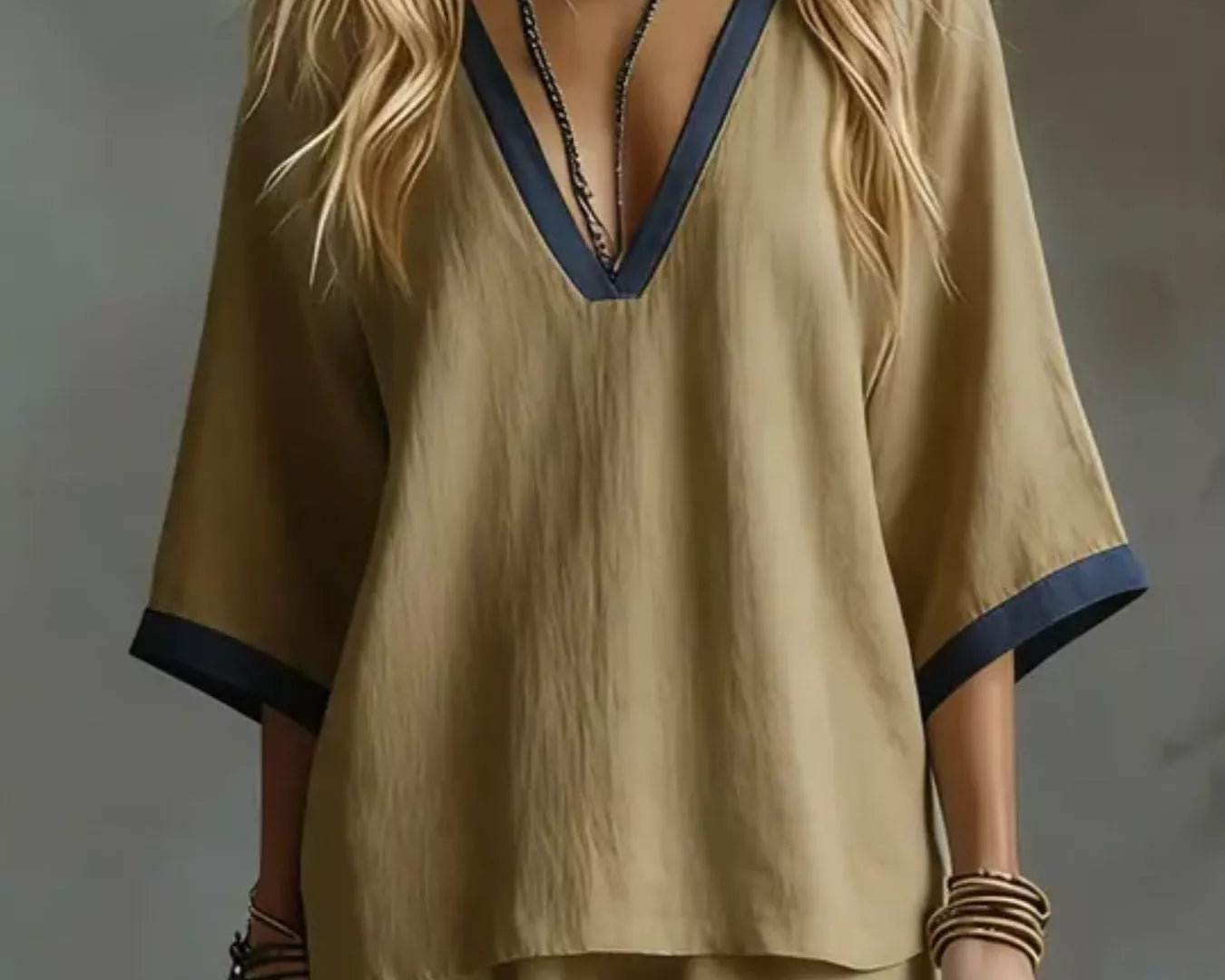 NEWYORKLISTED STYLE COLLECTION: Woman wearing a beige outfit with a deep neckline against a gray background