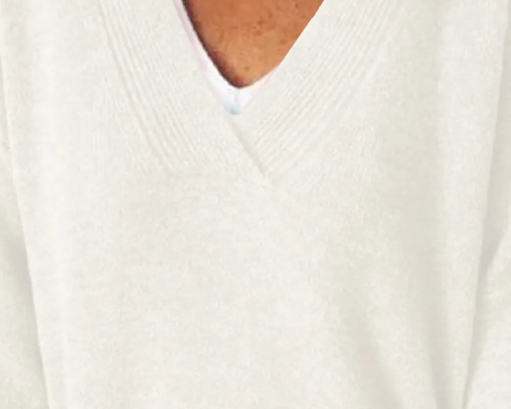 NEWYORKLISTED STYLE COLLECTION: Close-up of a person wearing a white sweater with a V-neck