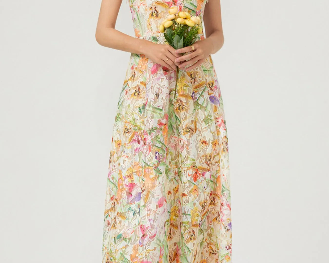 NEWYORKLISTED STYLE COLLECTION: Woman wearing a floral dress holding flowers on a white background