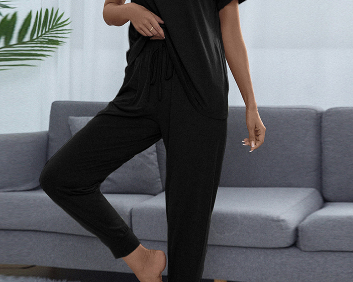 NEWYORKLISTED Intimate Apparel: Person wearing a black outfit standing in front of a gray sofa.