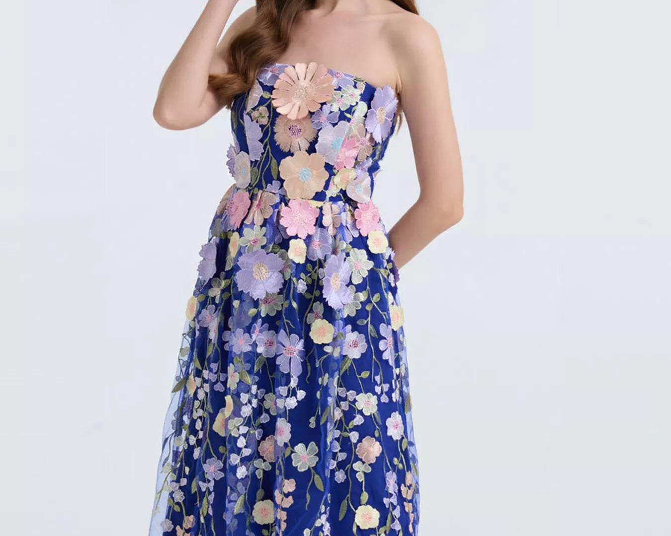NEWYORKLISTED STYLE COLLECTION: Woman wearing a strapless floral dress on a white background