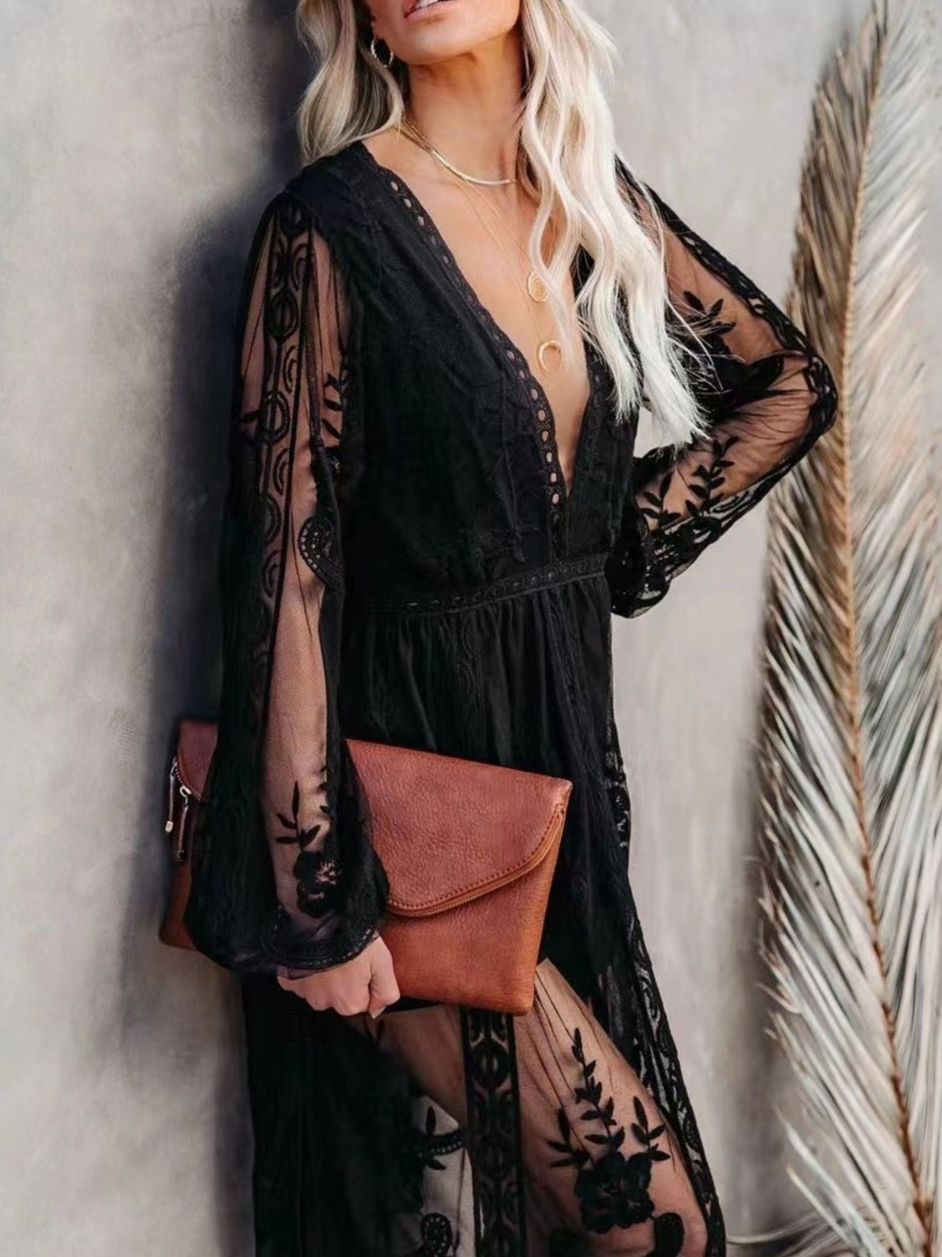 NEWYORKLISTED STYLE COLLECTION: Woman wearing a black lace dress with sheer sleeves against a neutral background