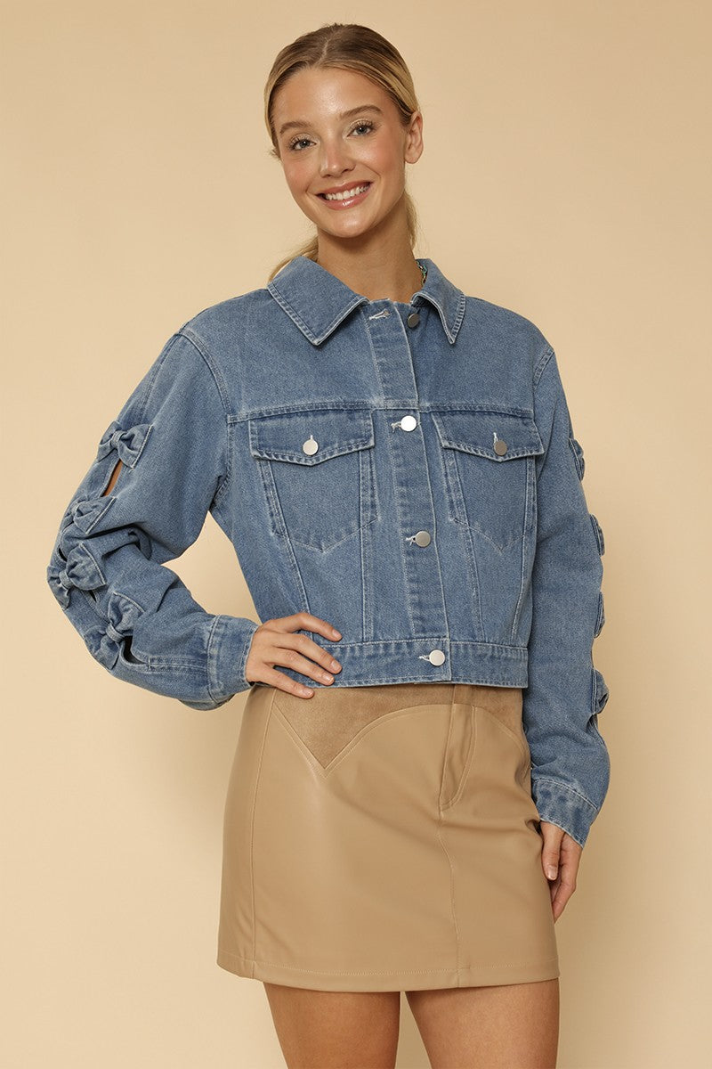 NEWYORKLISTED STYLE COLLECTION: Woman wearing a blue denim jacket and beige skirt on a beige background