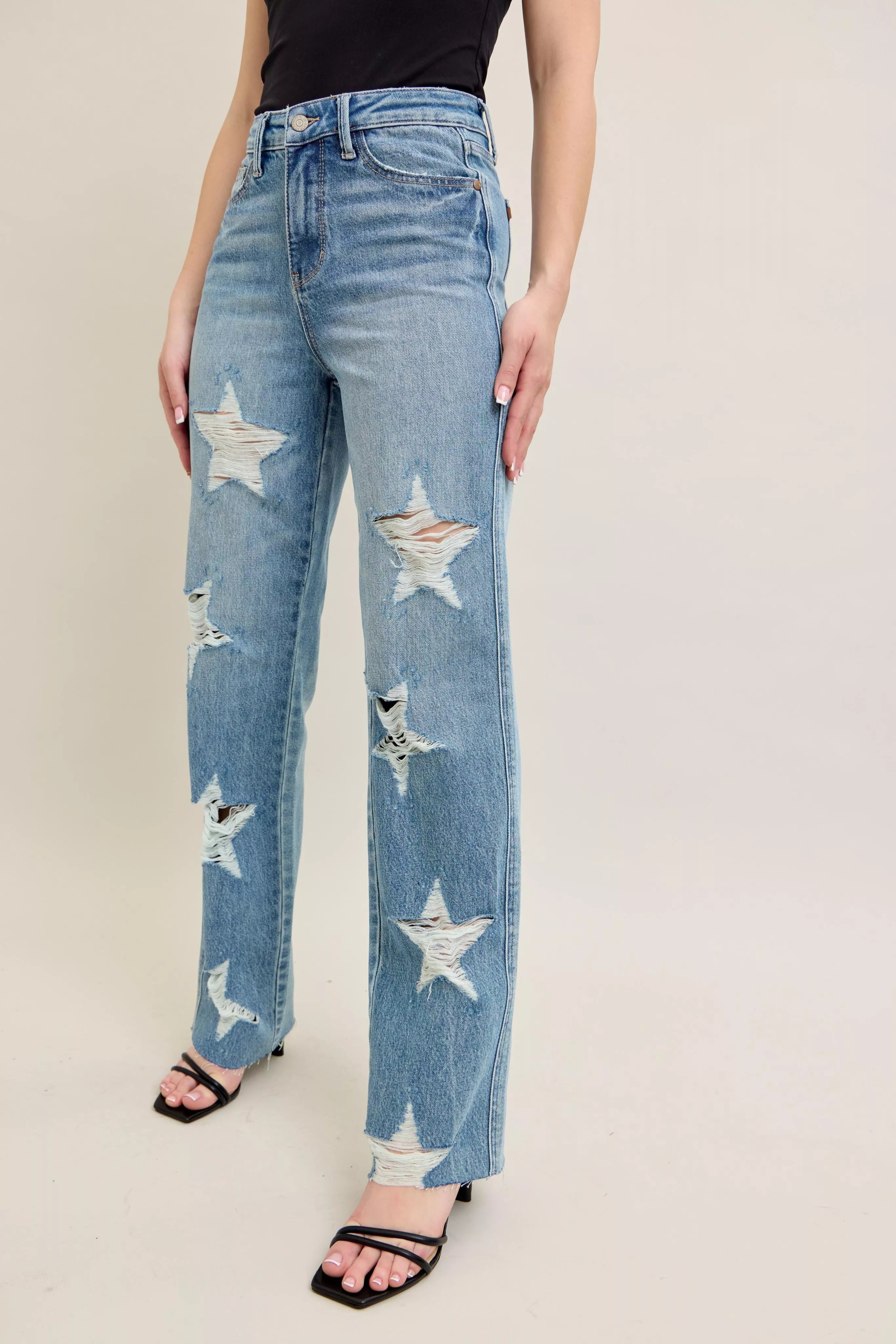 NEWYORKLISTED STYLE COLLECTION: Blue jeans with star patterns worn by a person on a plain background
