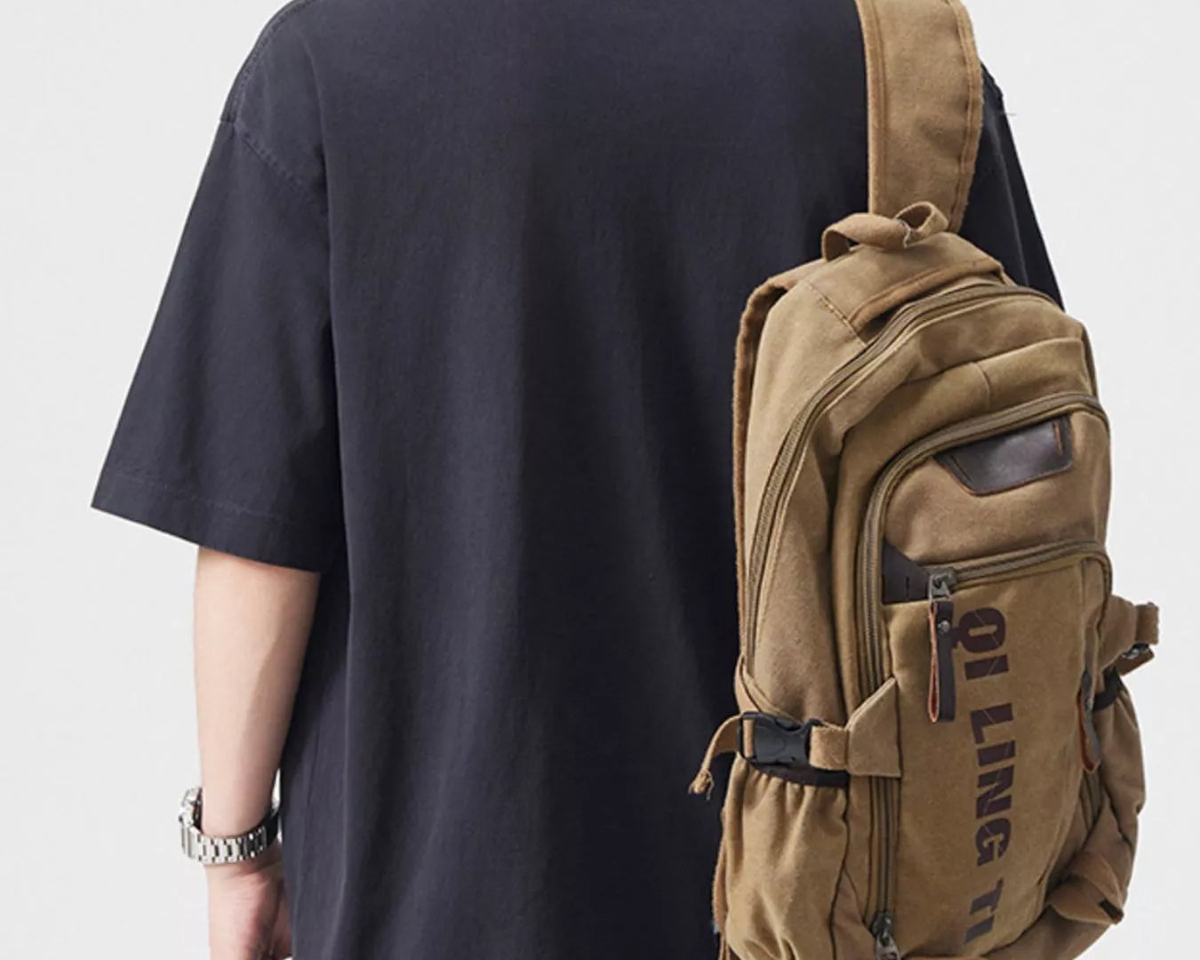 NEWYORKLISTED ATLAS MEN's COLLECTION: Person wearing a black t-shirt and brown backpack on a plain background