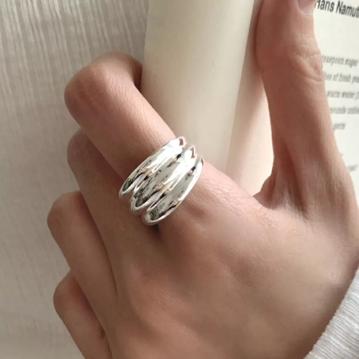 NYLD Glamour Collection: Silver ring on a finger with a blurred background