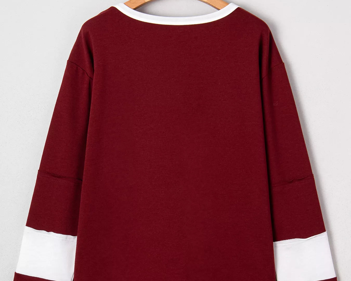 NEWYORKLISTED STYLE COLLECTION: Maroon long-sleeve shirt with white accents on a hanger against a light gray background