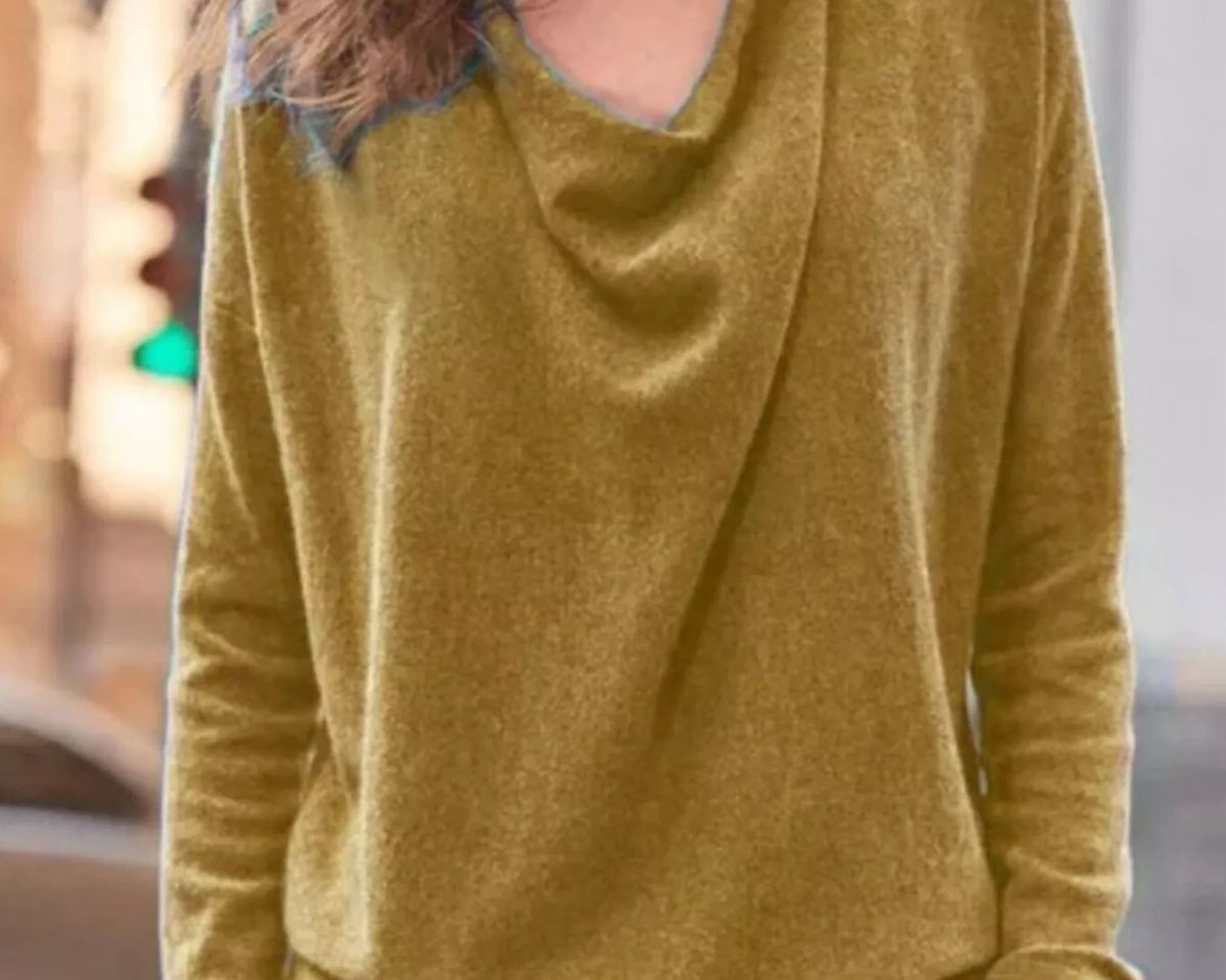 NEWYORKLISTED STYLE COLLECTION: Woman wearing a mustard yellow long-sleeve top with a blurred background