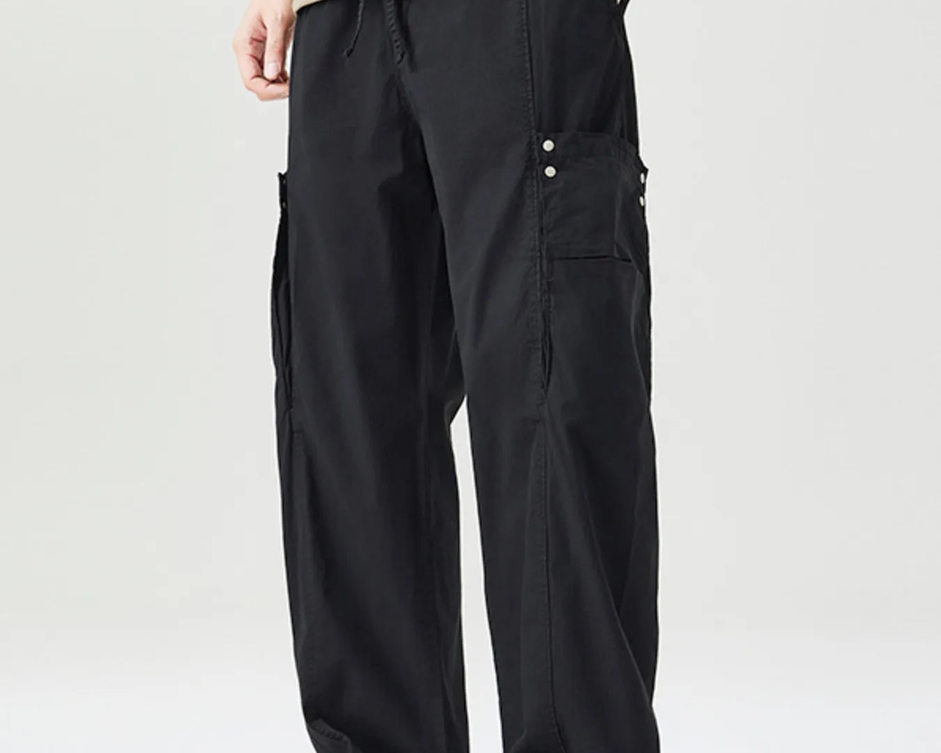 NEWYORKLISTED ATLAS MEN's COLLECTION: Person wearing black cargo pants and a beige shirt on a white background