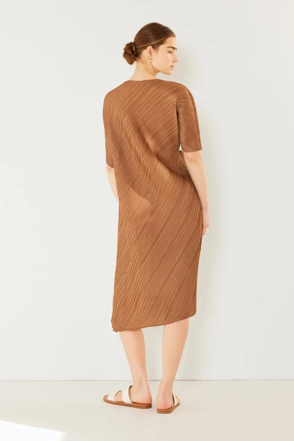 Woman wearing a brown dress against a white background: NEWYORKLISTED STYLE COLLECTION