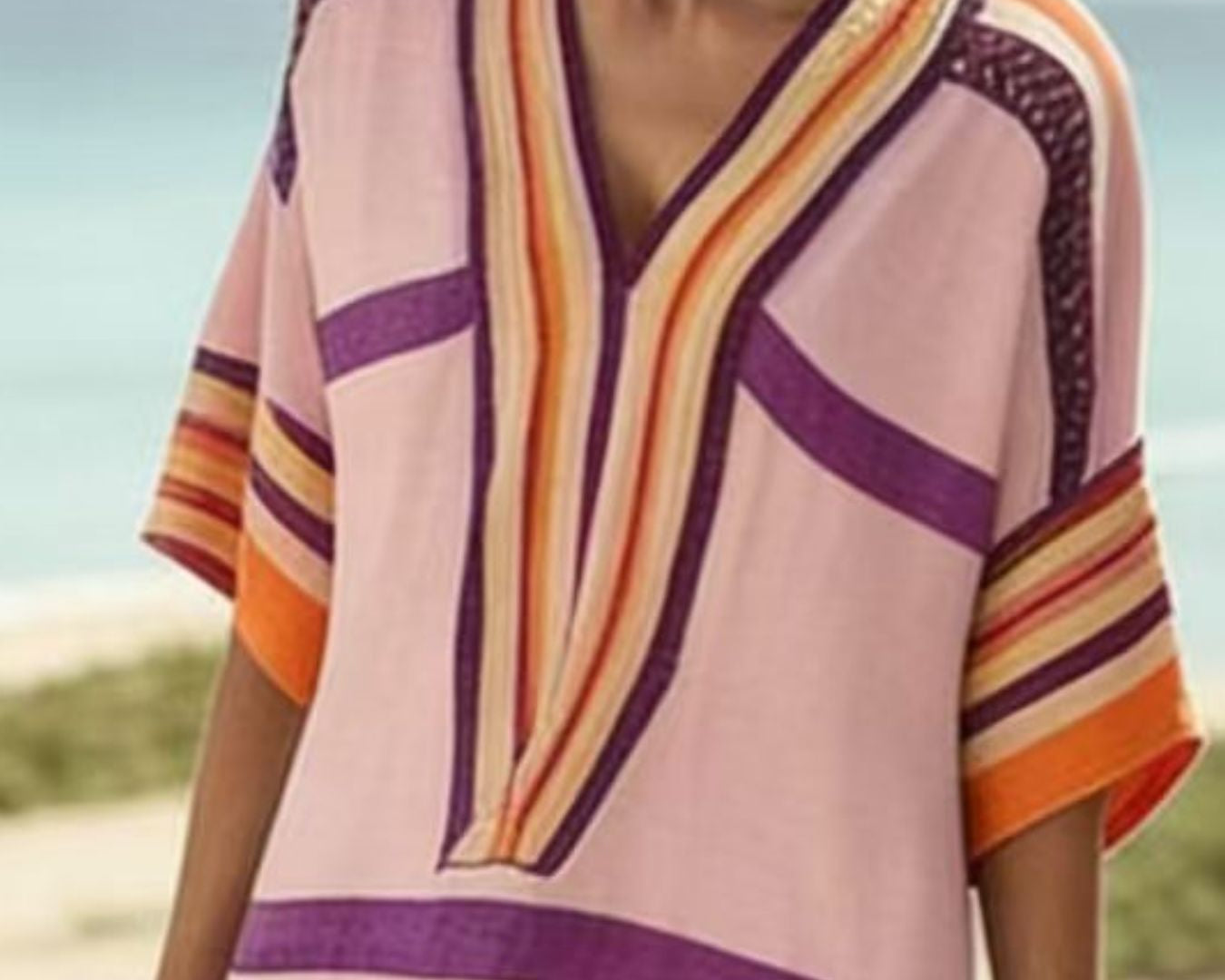 NEWYORKLISTED STYLE COLLECTION: Woman wearing a colorful striped top on a beach