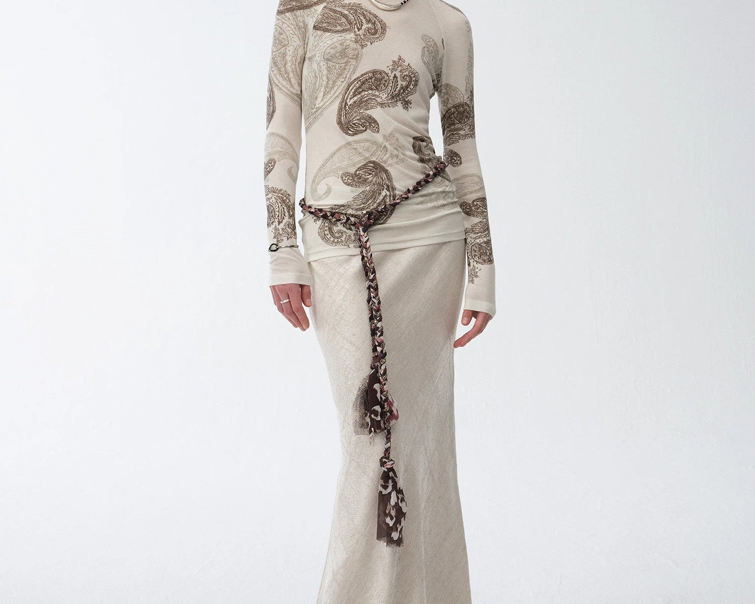 NEWYORKLISTES STYLE COLLECTION: Woman wearing a long, elegant dress with intricate patterns on a white background