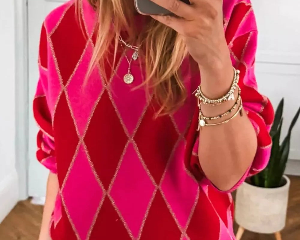 NEWYORKLISTED STYLE COLLECTION: Person wearing a pink argyle sweater taking a mirror selfie.