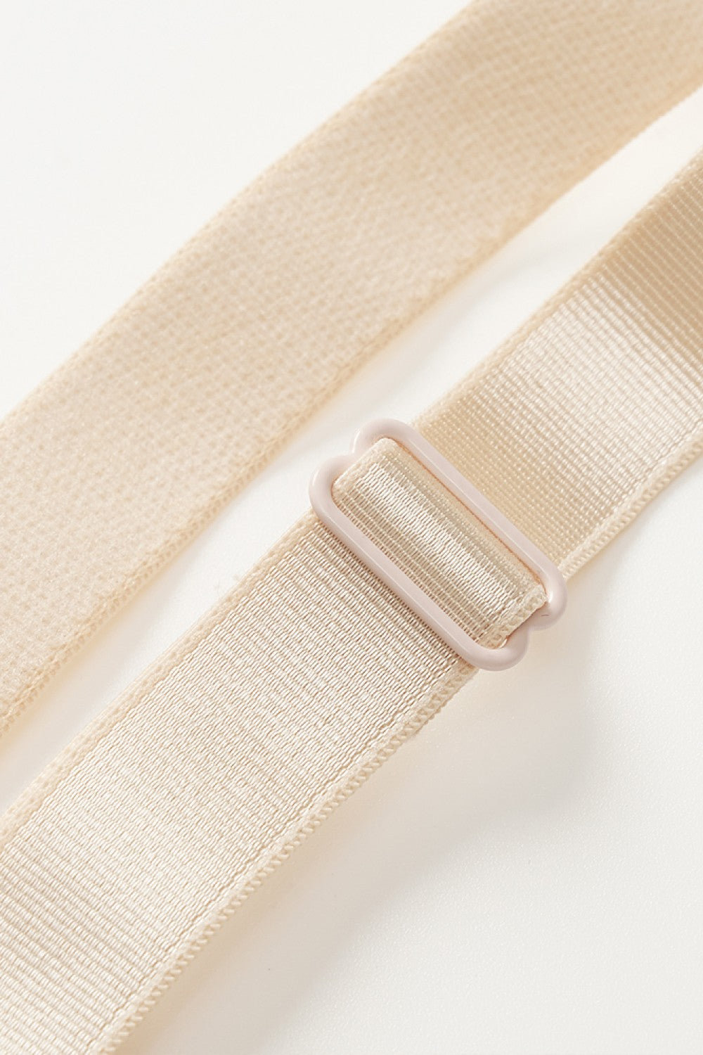 NEWYORKLISTED Intimate Apparel: Beige belt with a plastic buckle on a light gray background