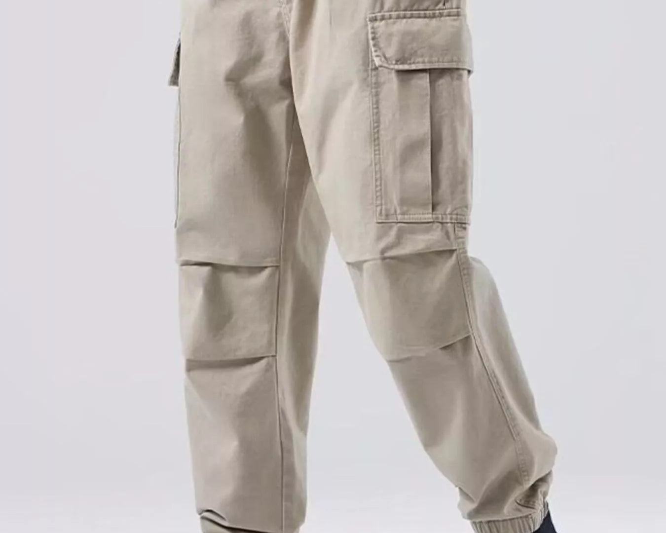 NEWYORKLISTED ATLAS MEN'S COLLECTION: Person wearing beige cargo pants with a plain background