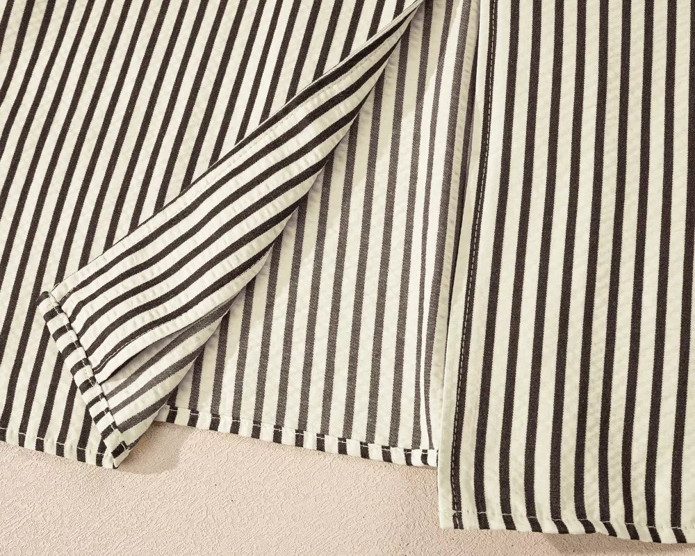 NEWYORKLISTED STYLE COLLECTION: Close-up of a black and white striped shirt on a beige background