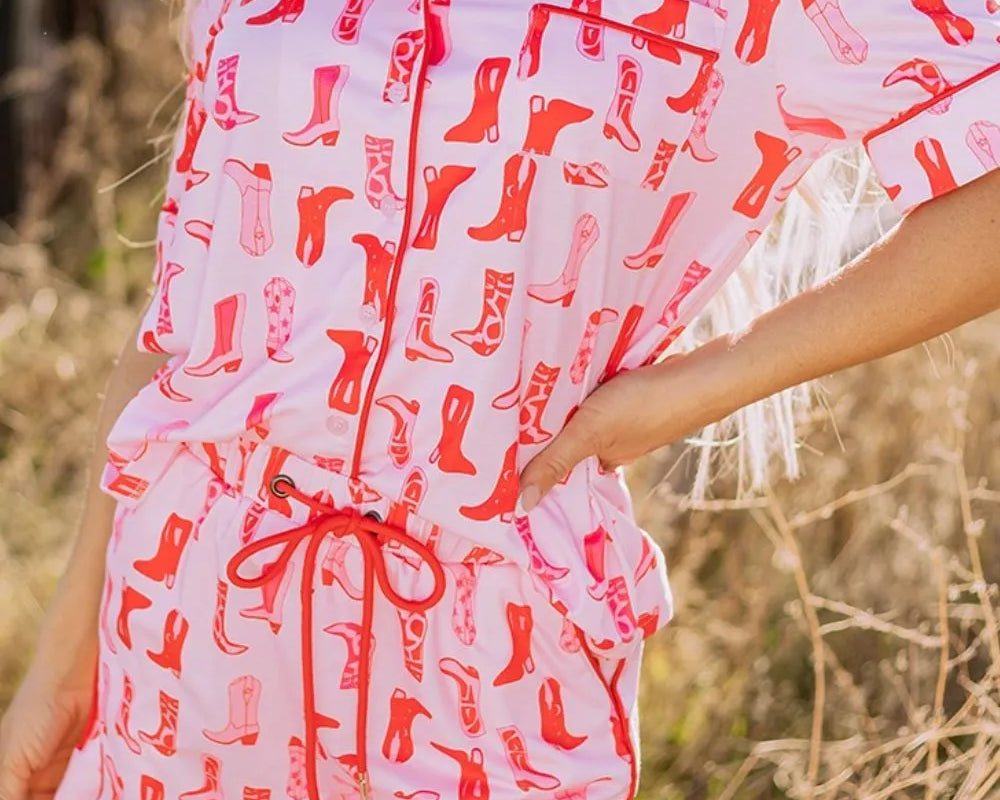 NEWYORKLISTED Intimate Apparel: Woman wearing a pink outfit with red boot pattern in a natural setting