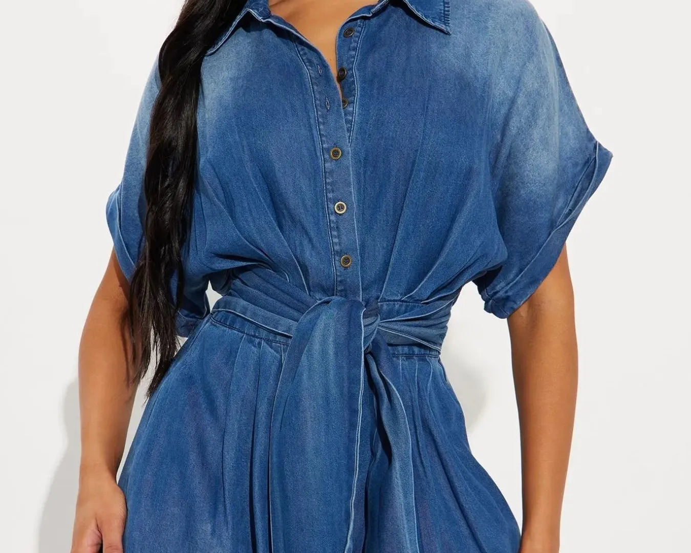 NEWYORKLISTED STYLE COLLECTION: Woman wearing a blue denim dress against a white background
