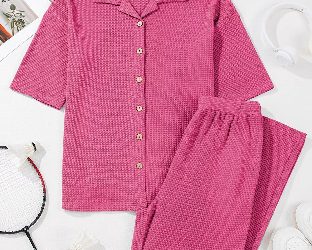 NEWYORKLISTED Comfort Collection: Pink checkered shirt and pants set on a white background with a badminton racket.