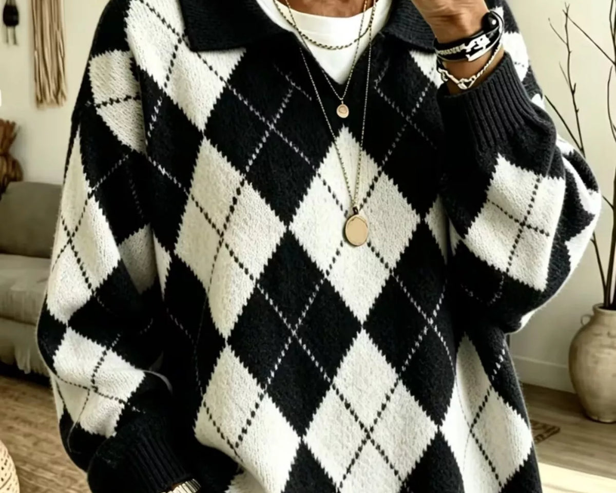 NEWYORKLISTED STYLE COLLECTION:A person taking a mirror selfie wearing a black and white argyle knit sweater over a white top, paired with light blue jeans and layered gold necklaces.