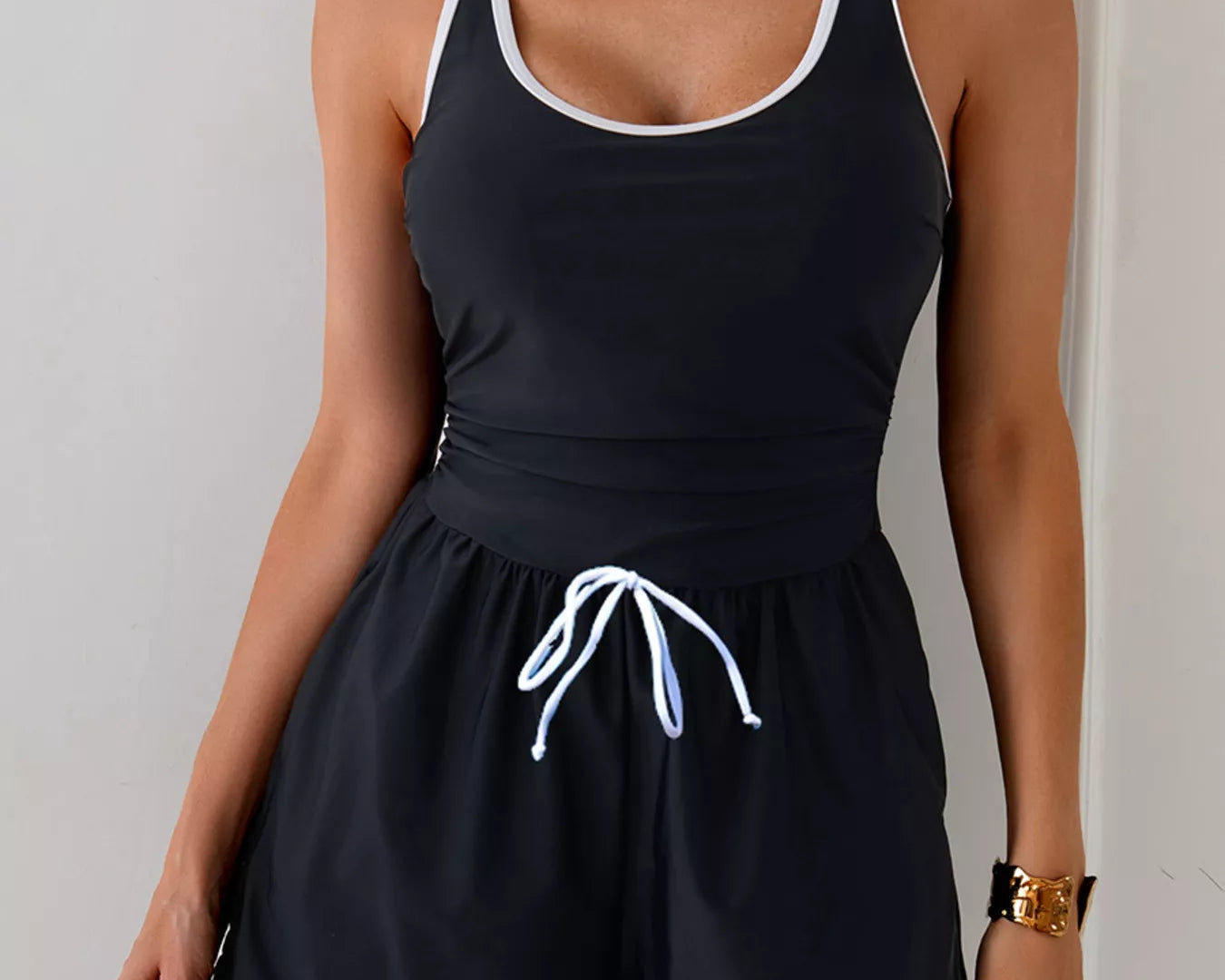 NEWYORKLISTED STYLE COLLECTION: Black tank top and shorts set with white trim on a plain background