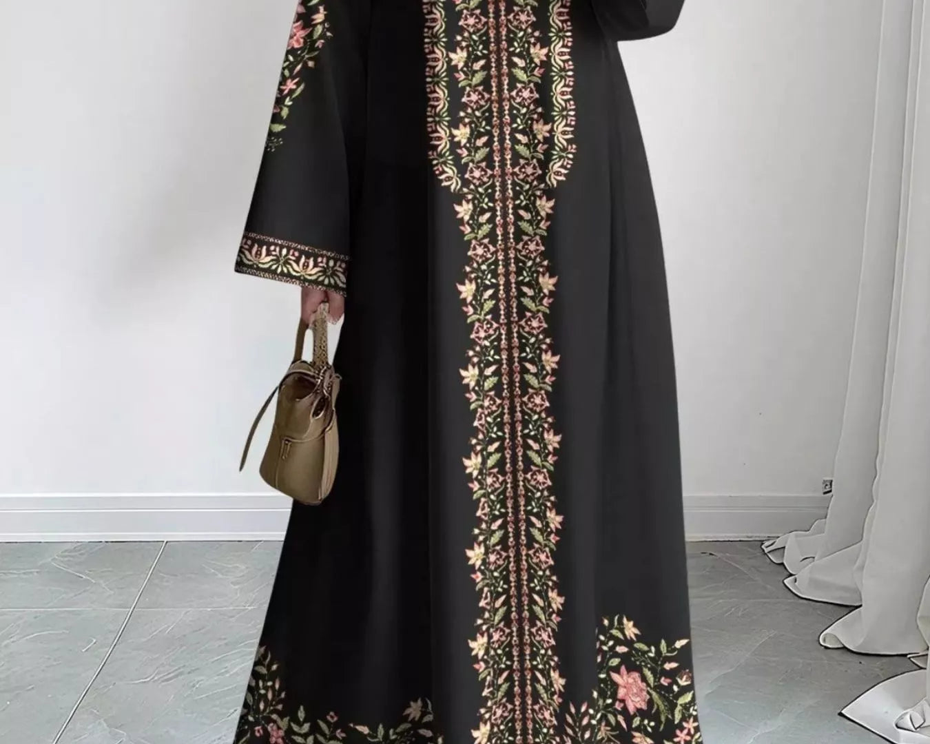 NEWYORKLISTED STYLE COLLECTION: Woman wearing a black dress with floral embroidery in a minimal indoor setting